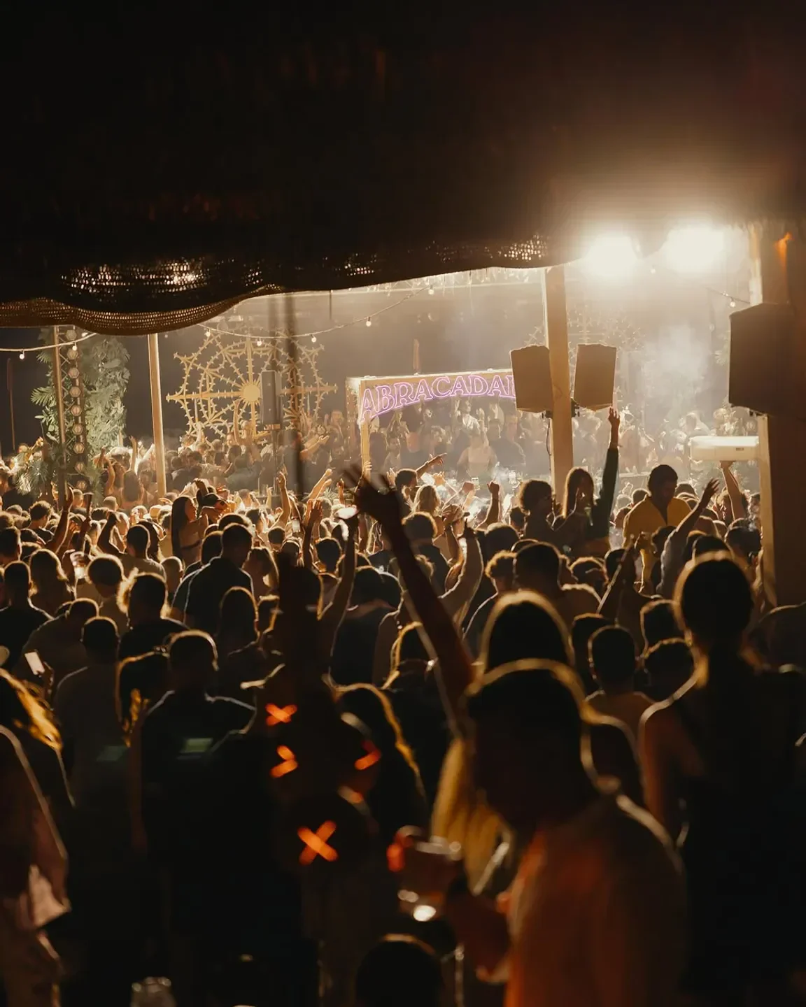 Energetic crowd partying at Alemagou Beach Club in Mykonos, under the lights.
