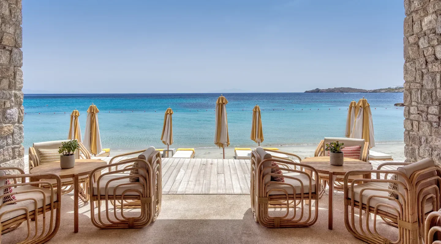 Buddha Bar Beach Mykonos with beachfront dining, chairs, umbrellas, and ocean views.
