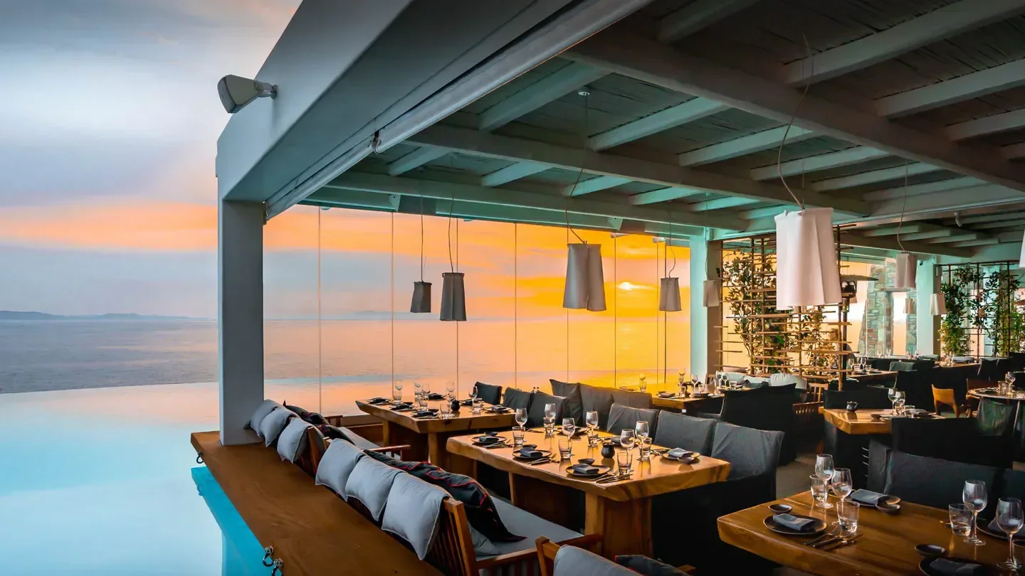Restaurant view at sunset at Cavo Tagoo Mykonos, Greece with sea views.