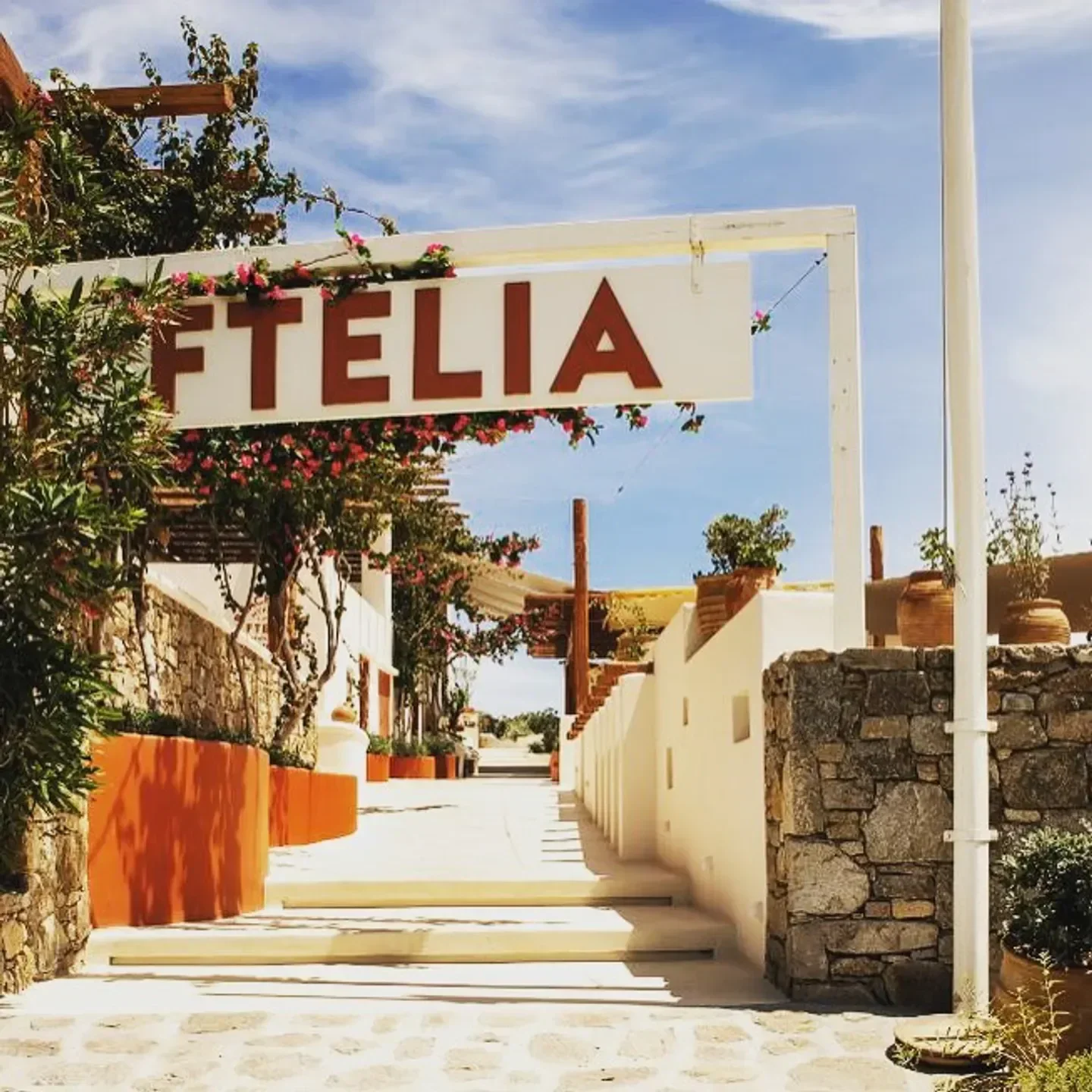 Entrance to Ftelia Beach Club in Mykonos, featuring a welcoming sign and stylish design.