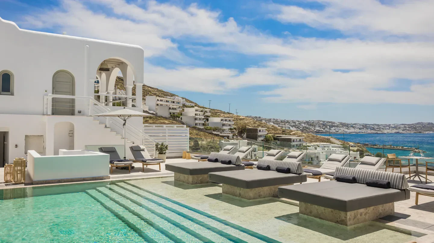Relaxing pool at Grace Mykonos hotel, offering stunning views of Mykonos island and the sea.