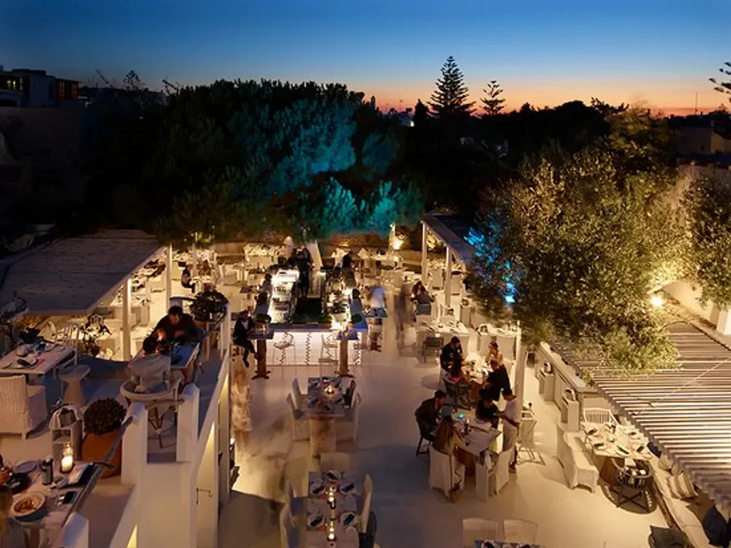 Interni restaurant in Mykonos at night, with outdoor dining under soft lighting.