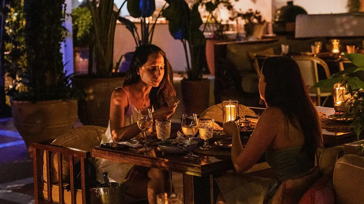 Dinner at ITA restaurant in Mykonos, Greece with two women enjoying drinks and a meal.