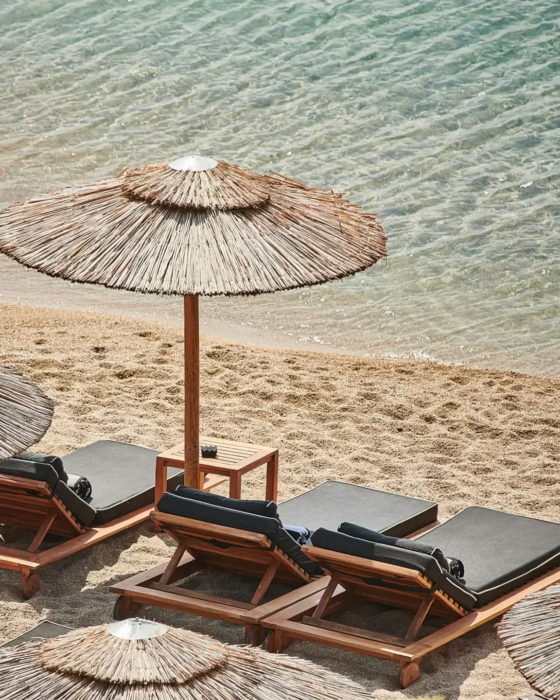 Beach lounge chairs and umbrellas at Jackie O' Beach Club in Mykonos, Greece