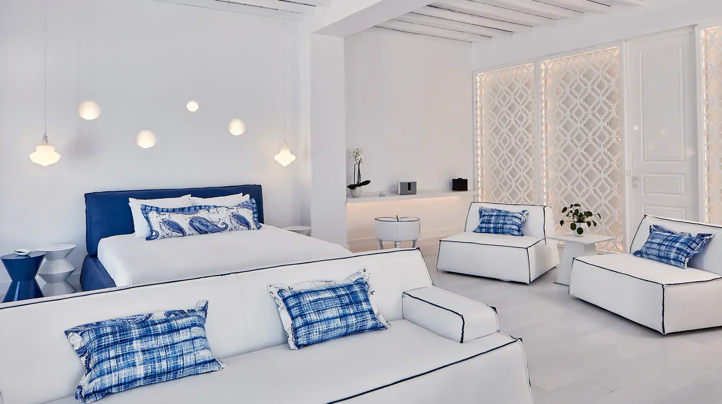 Stylish hotel room at Katikies Mykonos, featuring clean white design and blue accents.
