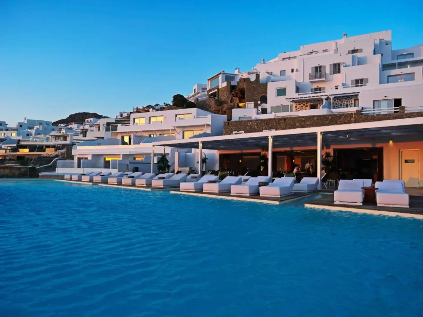 Poolside view of Kouros Hotel & Suites in Mykonos, offering luxury and relaxation.