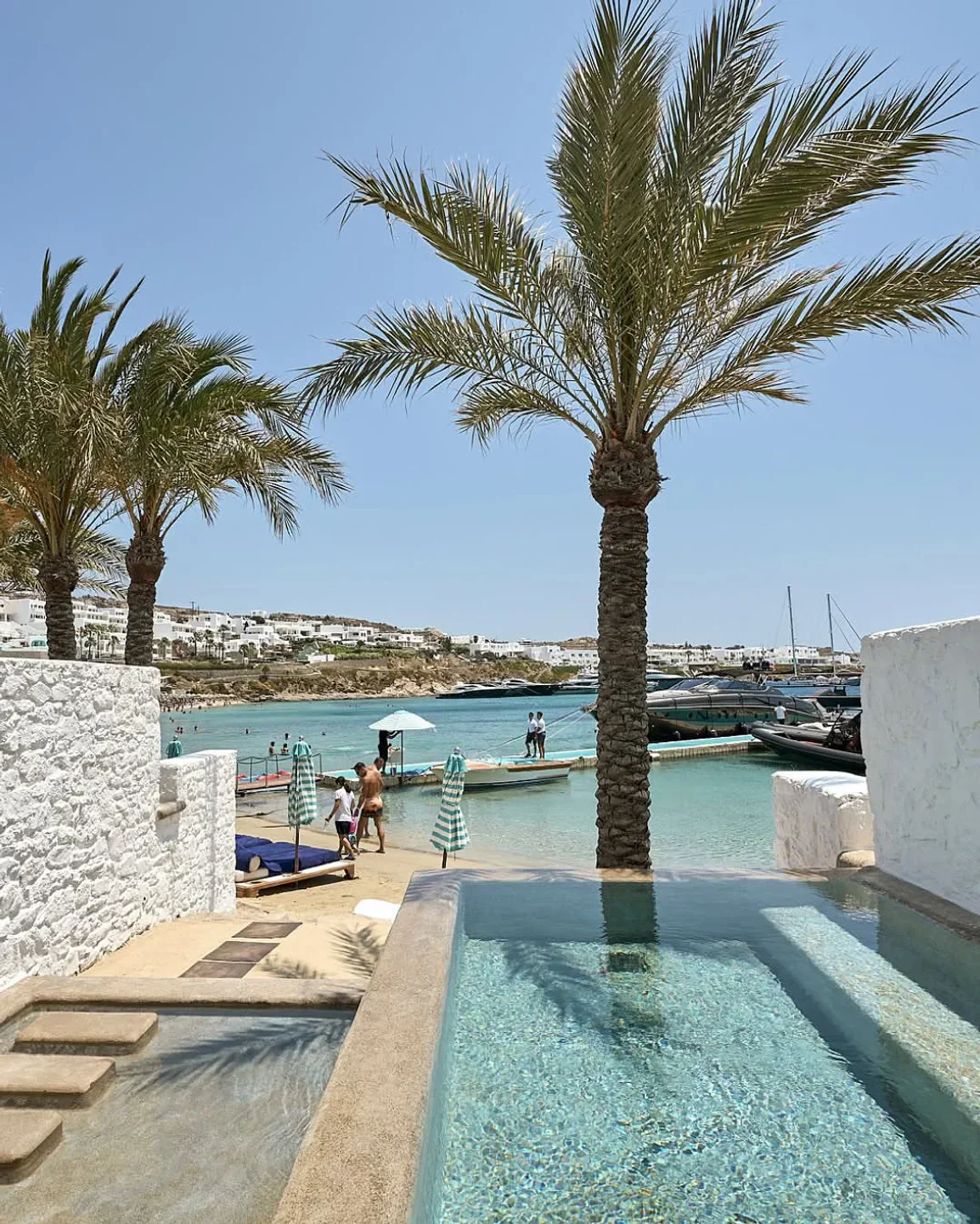 Nammos restaurant exterior in Mykonos with private pool, beach, and clear blue water.