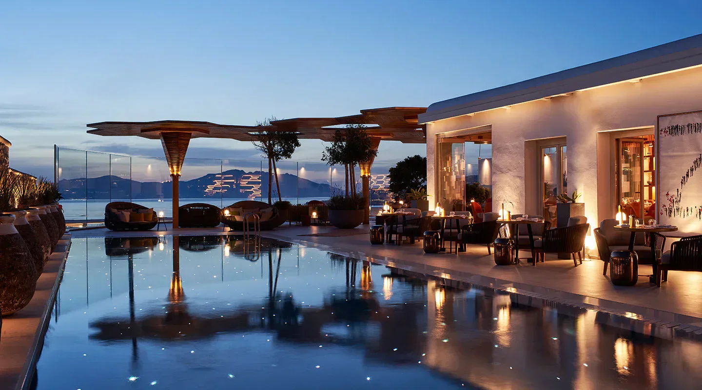 Naros restaurant in Mykonos at dusk with pool and outdoor seating