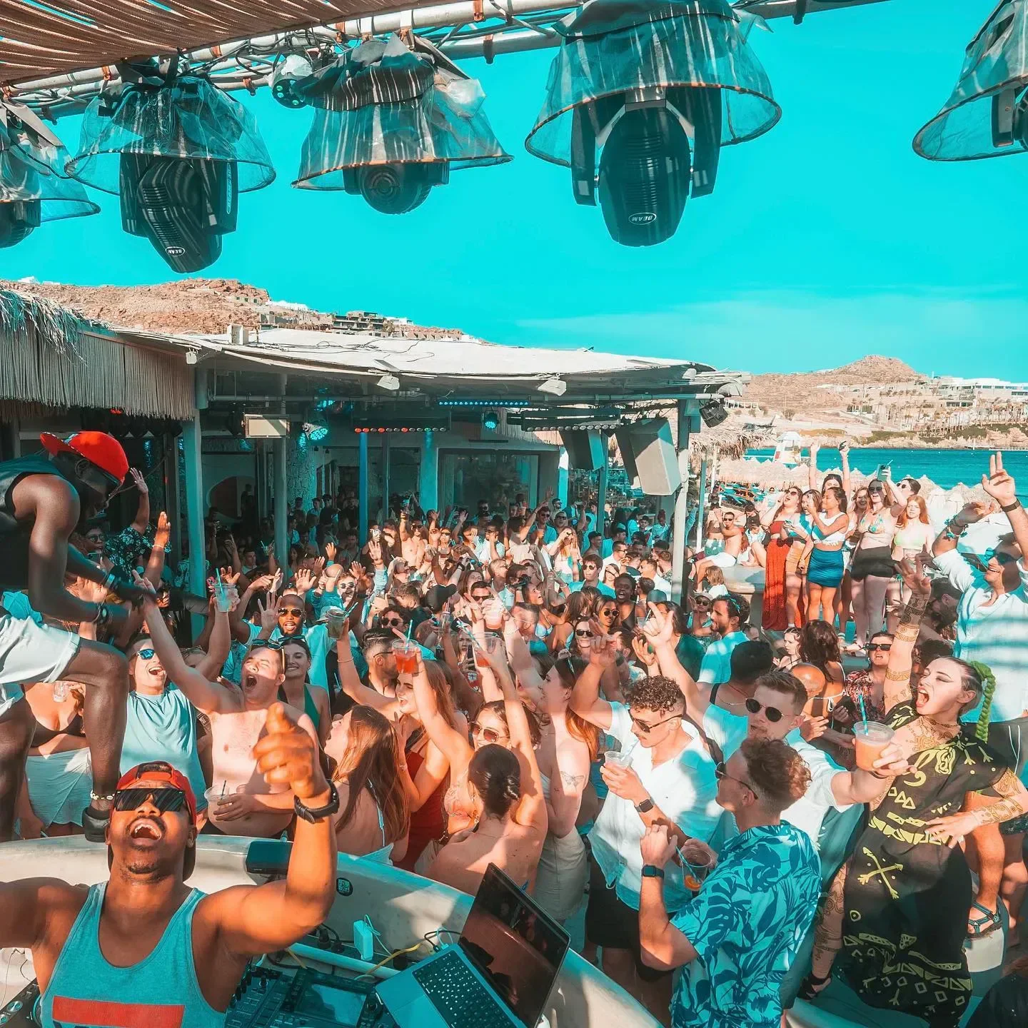 Energetic crowd partying at Paradise Beach Club in Mykonos, enjoying a summer night.