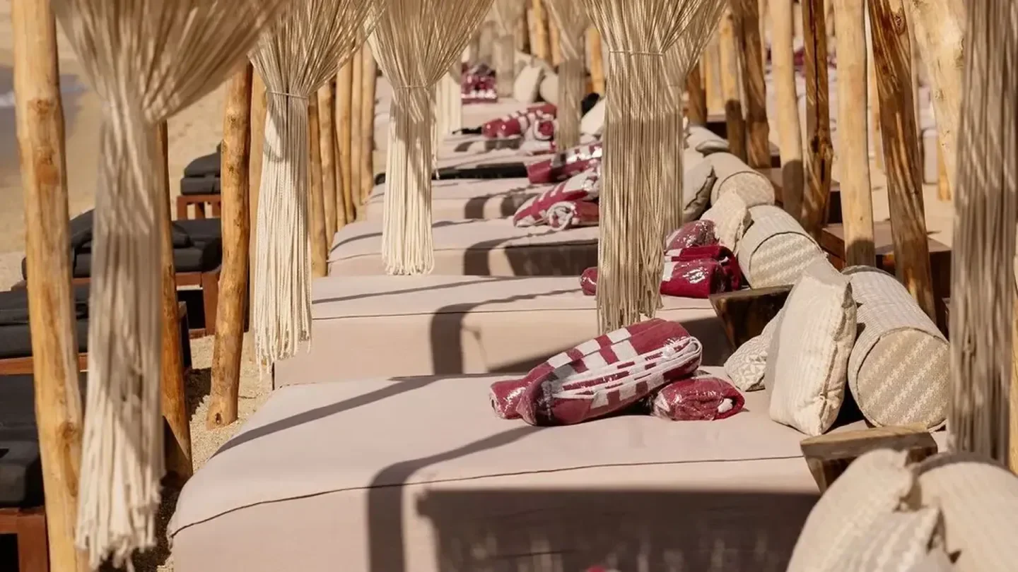 Relaxing day beds at SantAnna beach club in Mykonos, Greece with beach decor.
