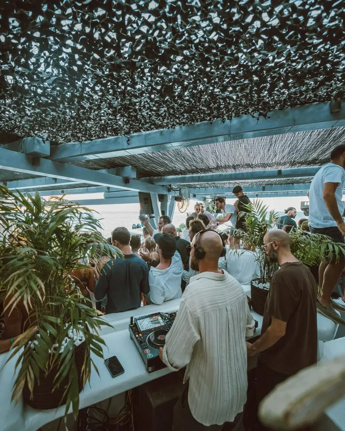 DJ set at Spilia beach club in Mykonos, with crowd enjoying the party.