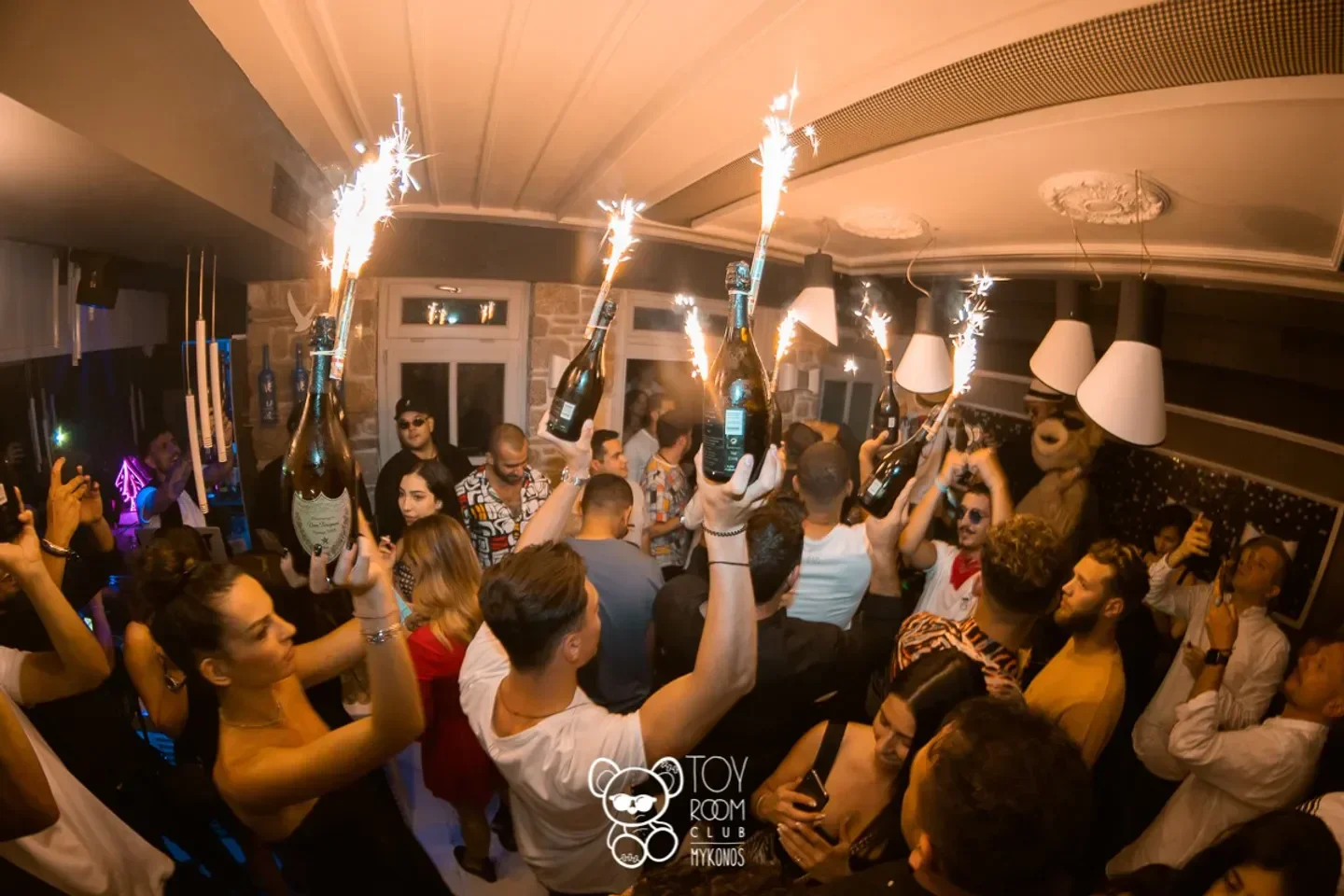 Champagne bottles with sparklers at ToyRoom Mykonos nightclub, celebrating a special night out.