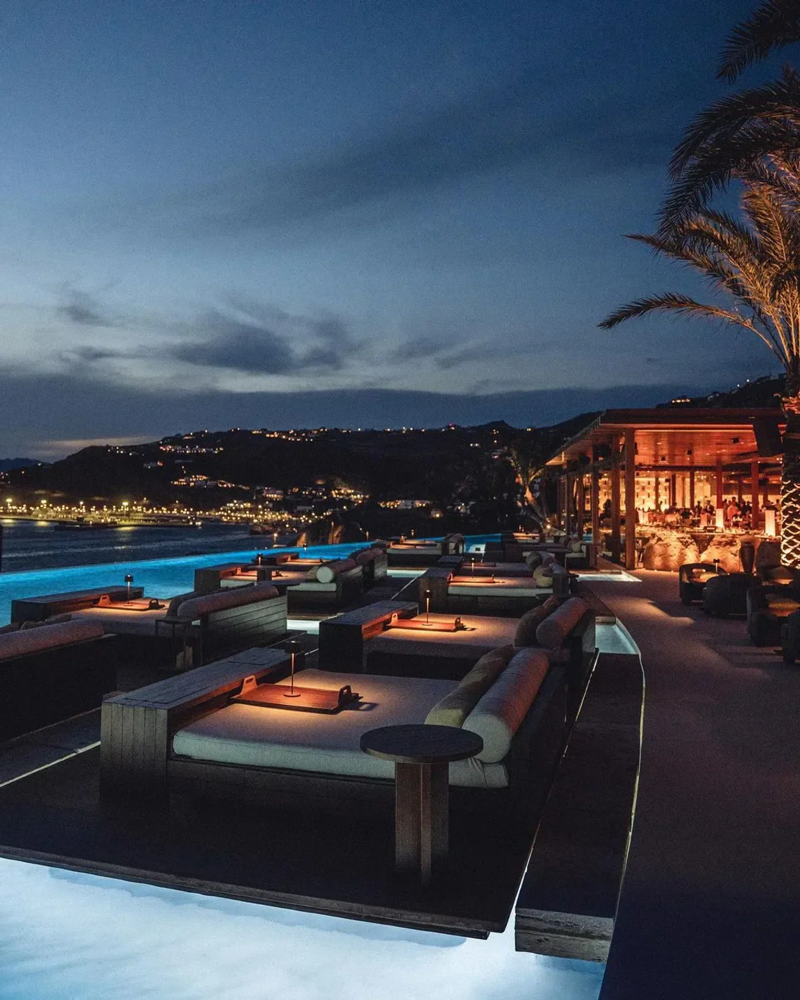 Night view of Zuma beach club in Mykonos, featuring stylish lounge beds and a pool